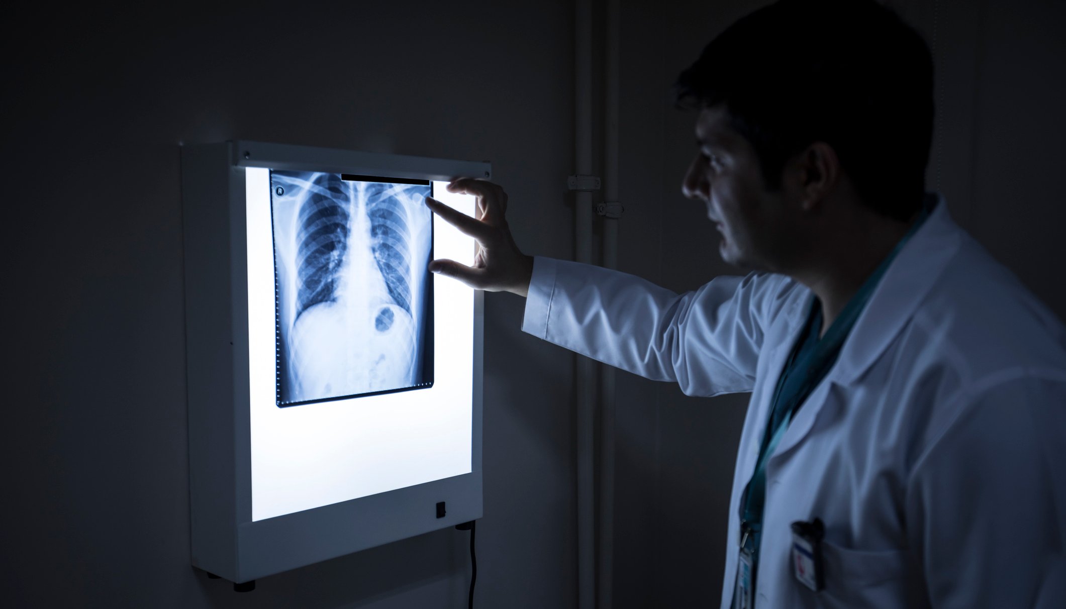 Doctor looking at an Xray in a dark room