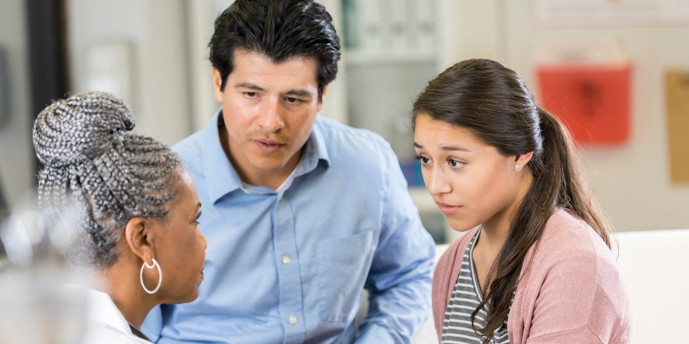 adolescent and parent consult with doctor