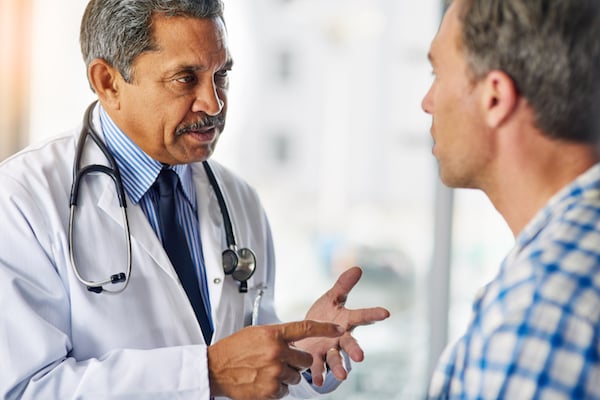 minority male doctor in a serious conversation with a patient to terminate the patient relationship