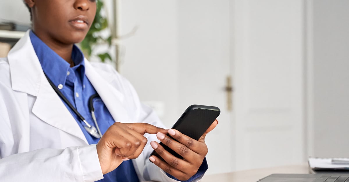 doctor texting at a desk