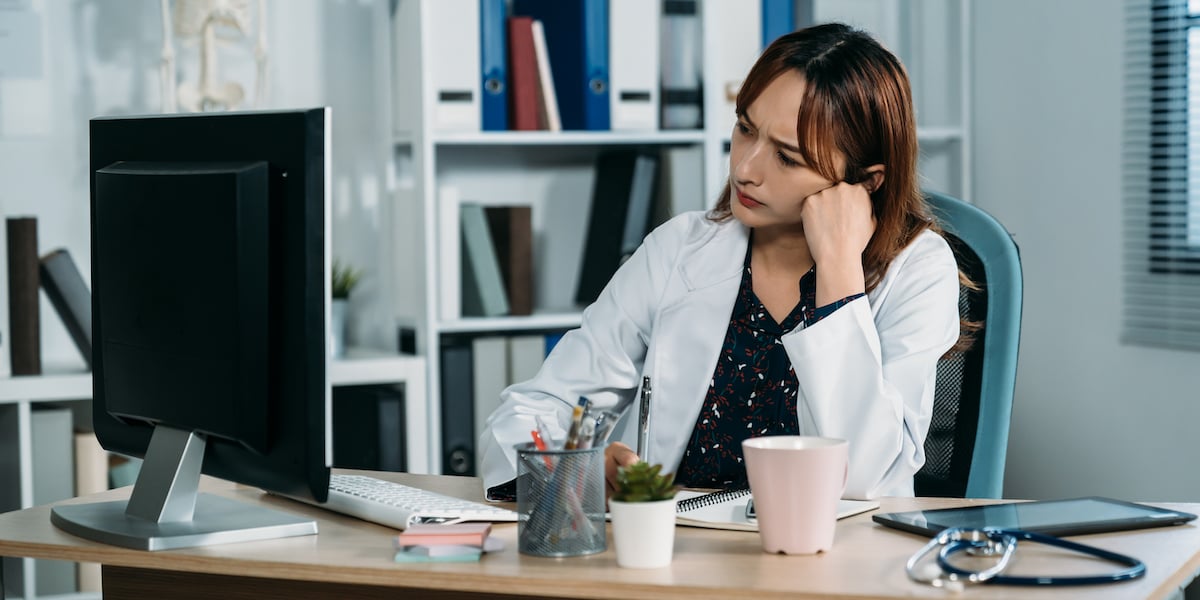 exhausted-doctor-looking-at-ehr-monitor_social