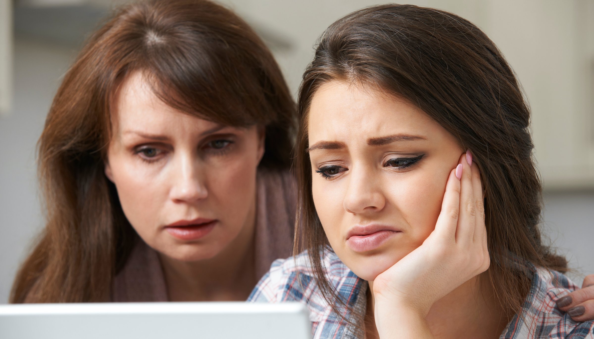 mother comforting daughter looking at medical record