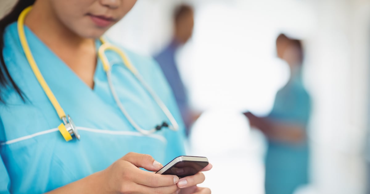 nurse text messaging on mobile phone