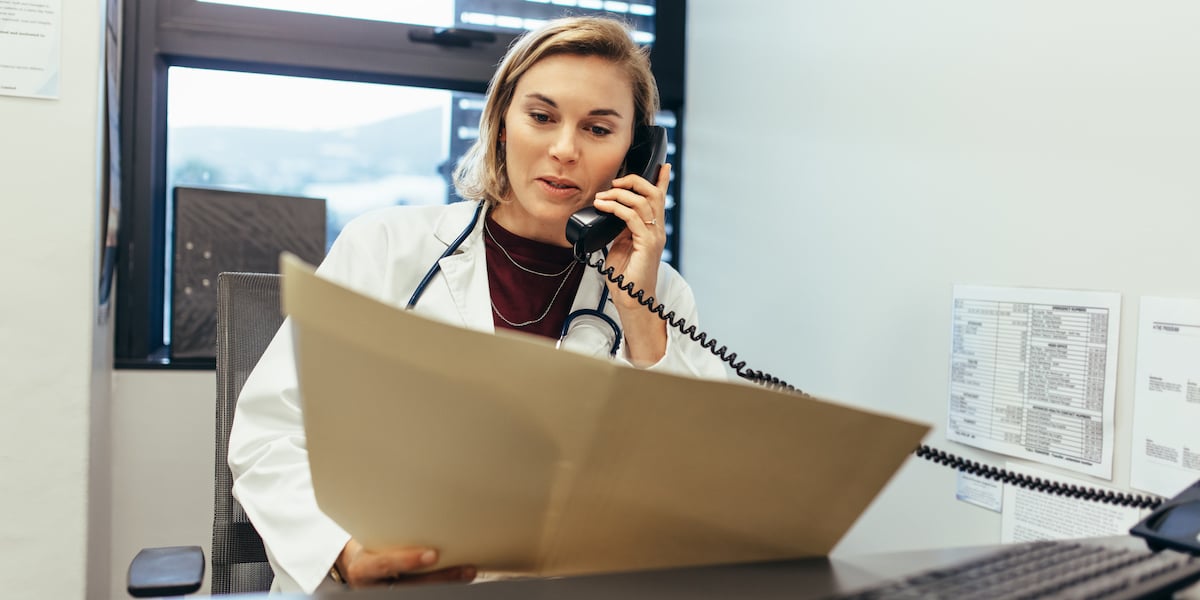 physician-on-phone-examining-medical-reports_soc