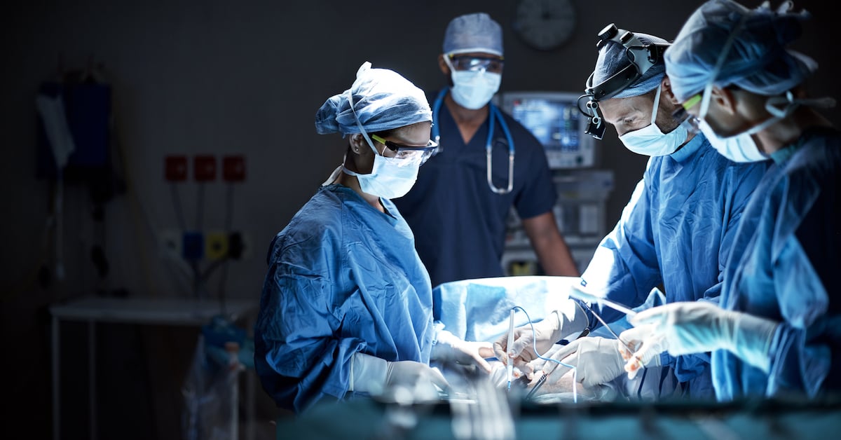 team of surgeons performing a surgery in an operating room